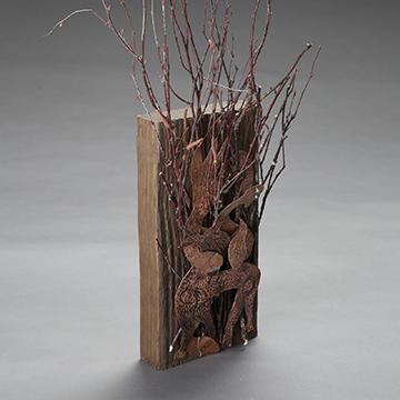 金属雕刻的草装在一块木头上
